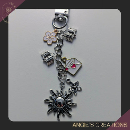 This mini Kindle charm chain is a perfect stocking stuffer or gift for readers who love books and flowers. Designed to add celestial touch to your Kindle, book sleeve, planner, tote bag, or key loop. Clips on easily and brings a bit of floral inspired magic to your reading routine. Each piece is assembled by hand in my Ottawa studio using a sturdy silver or gold clasp and chain (charms will be mixed in silver or gold), accented with 4 enamel charms, and 1 sun ending charm.