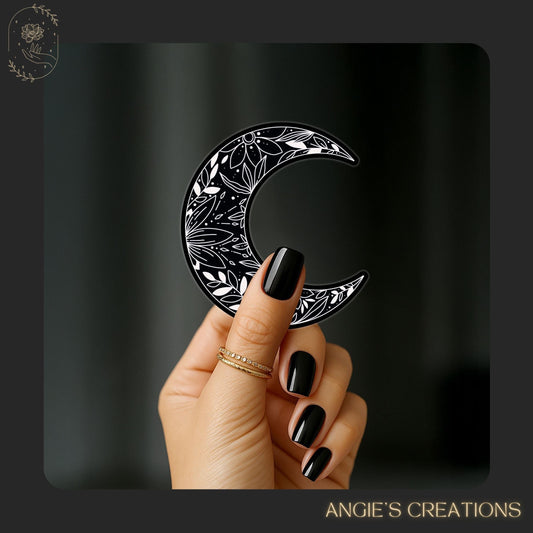 This floral crescent moon sticker is the perfect mix of dark elegance and celestial charm. With a sleek black background and delicate white floral patterning, it makes a beautiful addition to your bookish collection, journaling spreads, or tech accessories.