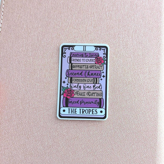 Pink notebook with a colorful card featuring text and graphics on a blurred background