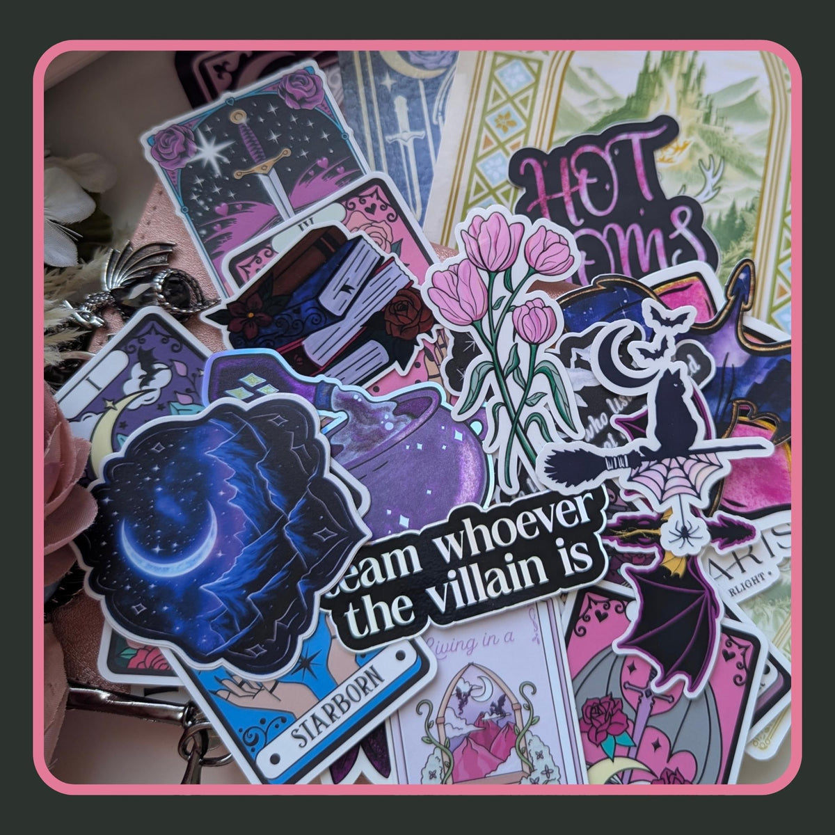 Collection of romantasy themed stickers featuring tarot cards, a bubbling cauldron, pink tulips, a witch flying on a broomstick, a black dragon, and a "team whoever the villain is" quote sticker. Angie's Creations bookish sticker pack for fantasy and dark academia readers.