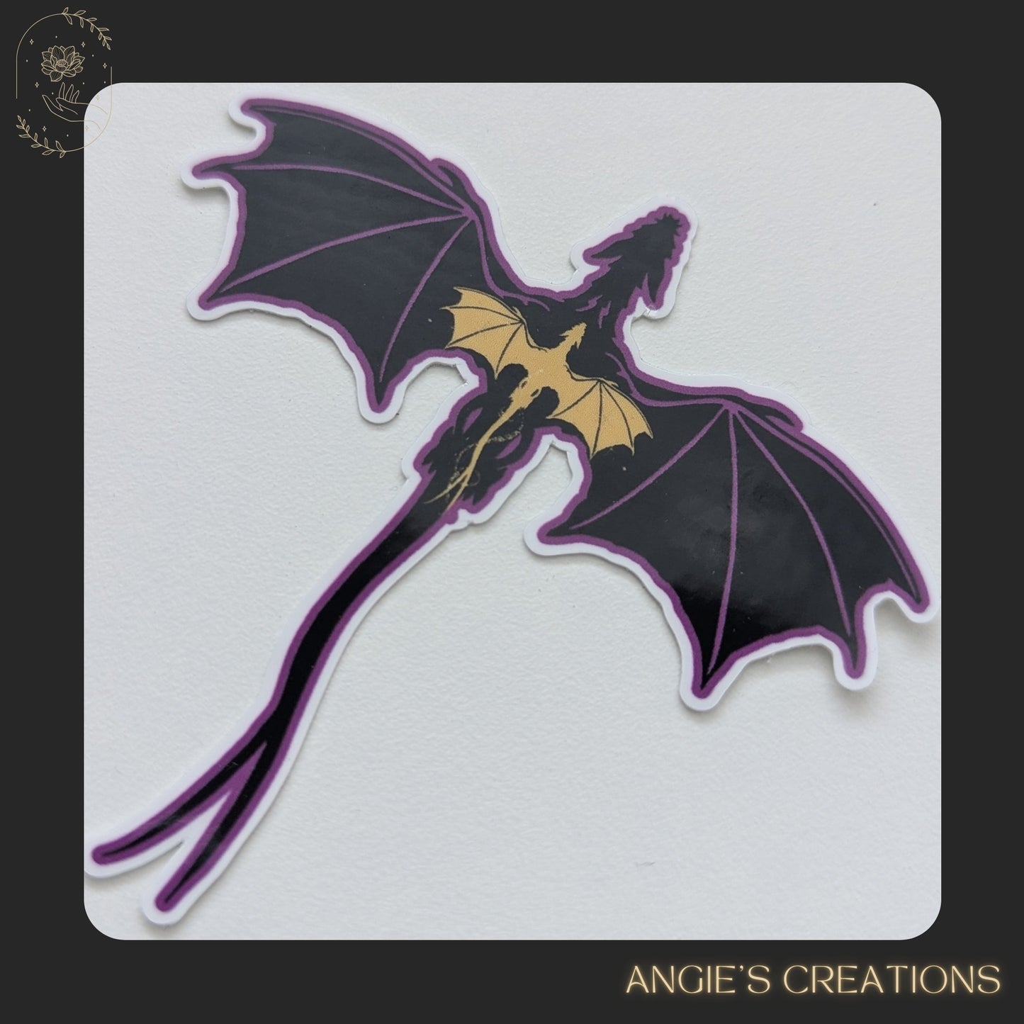 A sticker depicting a purple dragon with yellow accents, resembling a mythical creature.