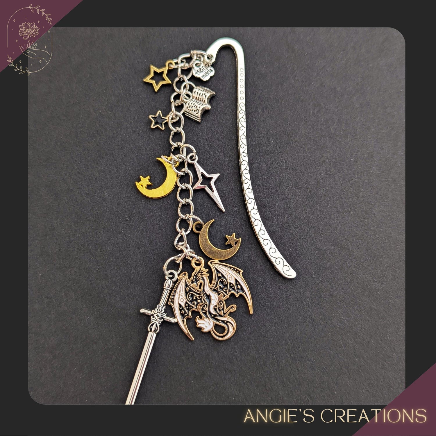 A fantasy-inspired metal bookmark featuring a detailed dragon charm, a silver sword, crescent moons, and tiny stars hanging from an engraved swirl bookmark hook, styled in mixed gold and silver tones with a celestial romantasy aesthetic perfect for book lovers, BookTok readers, and dragon fantasy fans.