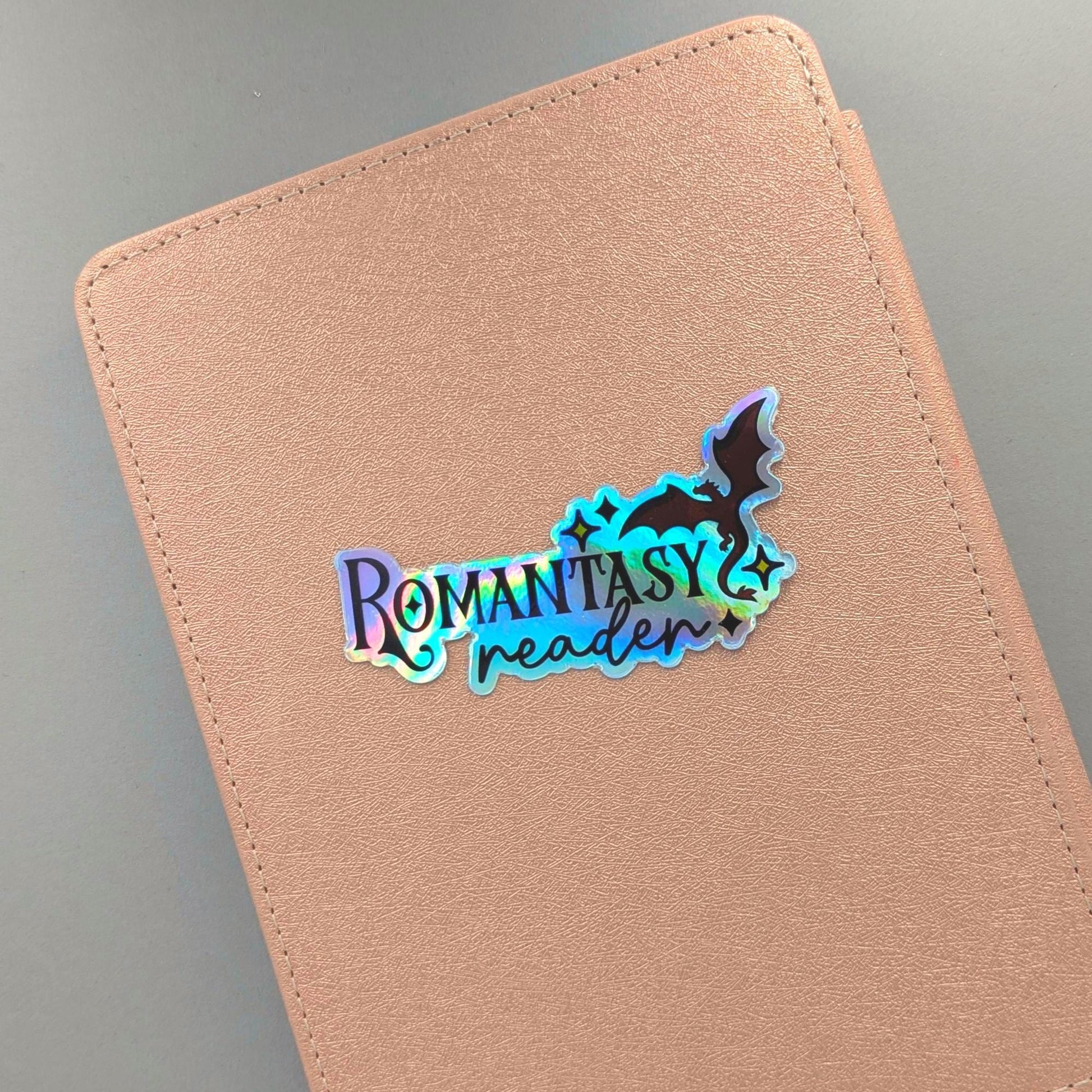 You didn't choose the romantasy life. It chose you. One chapter became one series became a TBR with its own postal code. This holographic sticker is for the girlie with a dragon on her Kindle, a book boyfriend in her heart, and zero apologies about either.