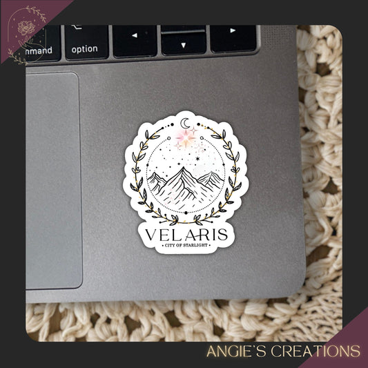 A sticker with a mountain landscape and a moon on a laptop keyboard.