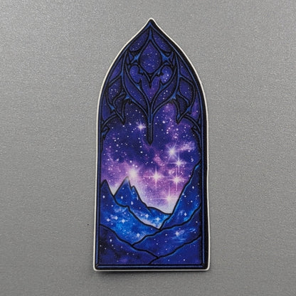Angie's Creations waterproof die-cut sticker featuring a deep blue and purple galaxy night sky viewed through an ornate gothic cathedral arch with dark decorative stonework and glowing mountain silhouettes. ACOTAR, Fourth Wing, and dark romantasy inspired waterproof sticker designed in Ottawa Canada, perfect for Kindle cases, laptops, water bottles, and journals.