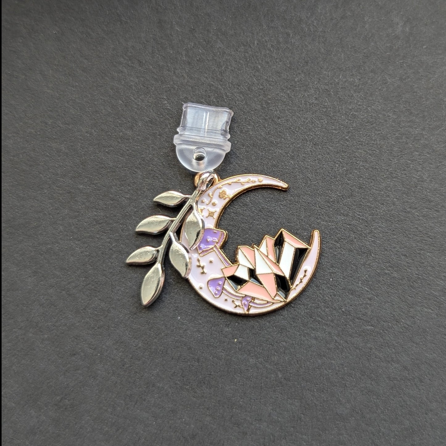 Angie's Creations hand-assembled USB-C dust plug featuring a gold crescent moon enamel charm with purple and pink geometric crystal detail and a silver botanical leaf branch accent charm. Celestial romantasy inspired phone or Kindle accessory handcrafted in Ottawa Canada.