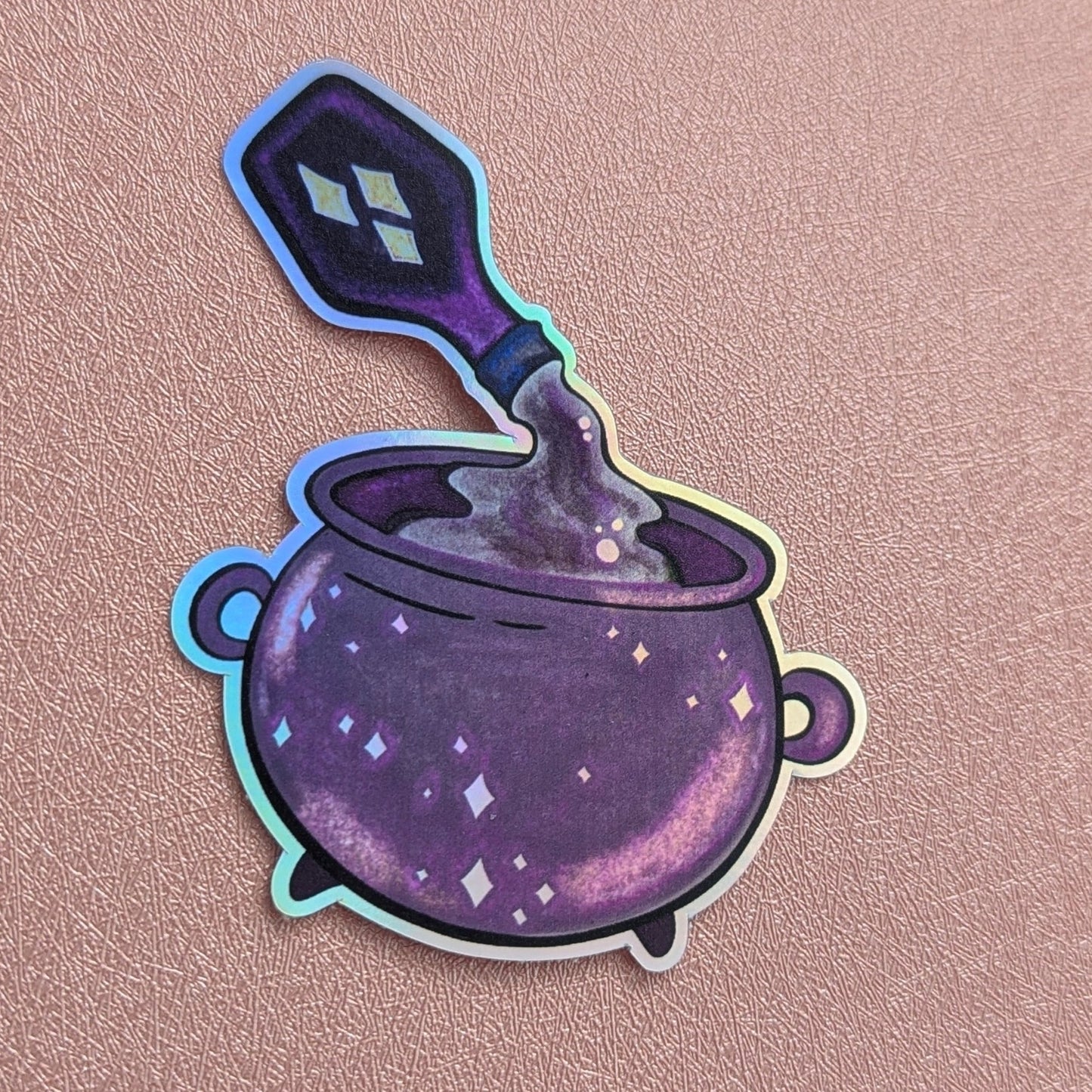 Sticker of a purple cauldron with a spoon on a pink background