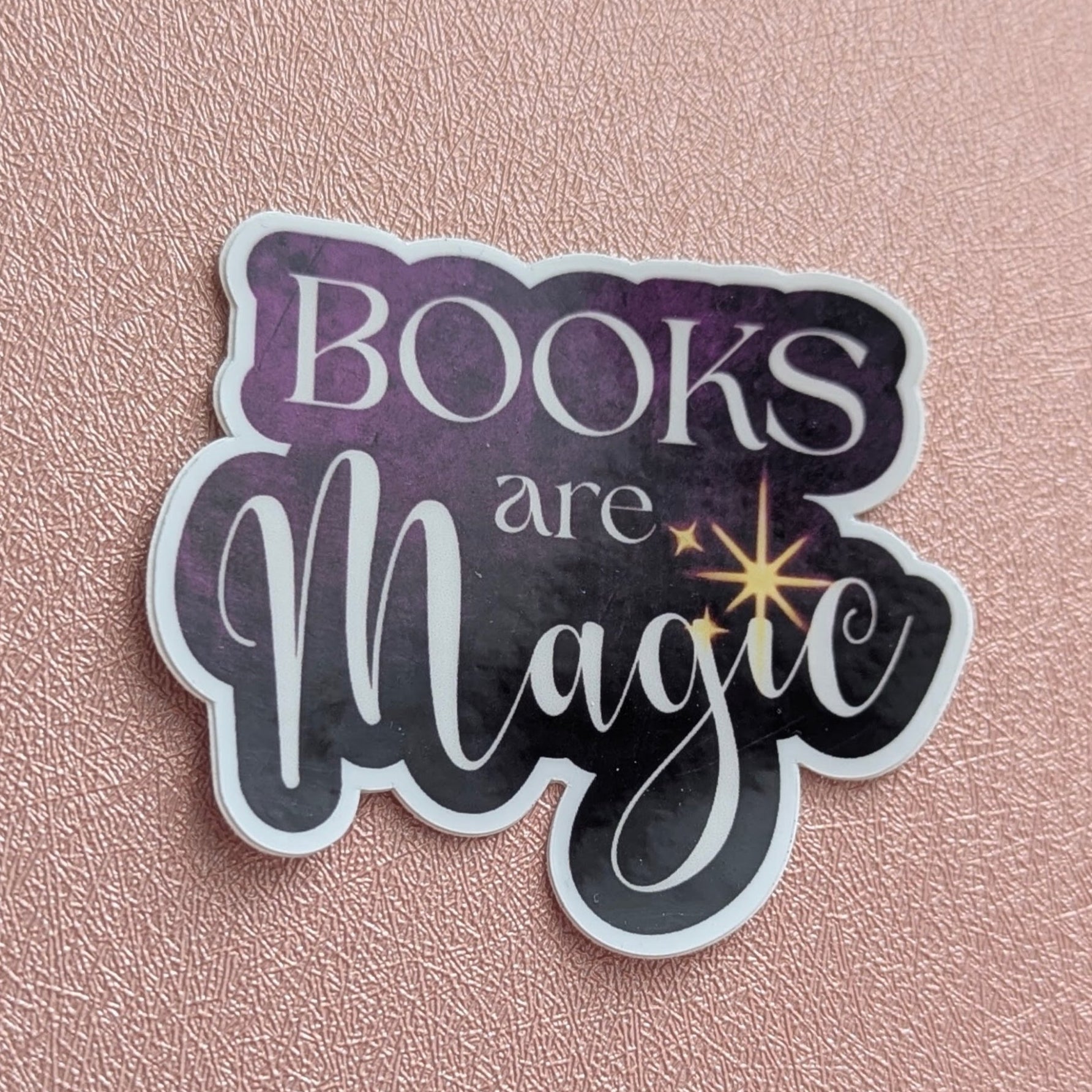 Sticker with 'Books are Magic' text on a pink background