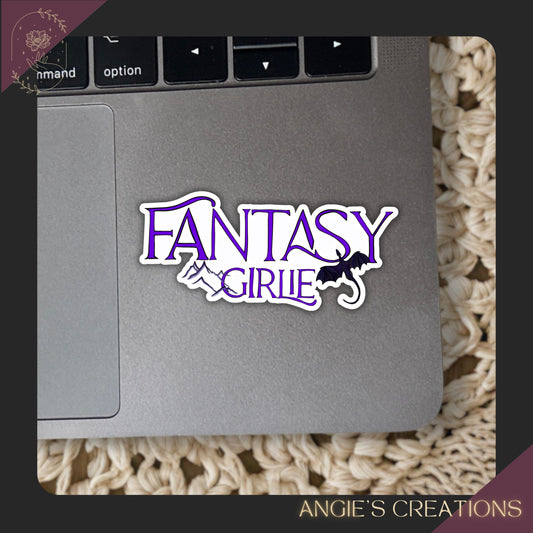 Sticker with 'Fantasy Girlie' design on a laptop trackpad, branded 'Angie's Creations'.