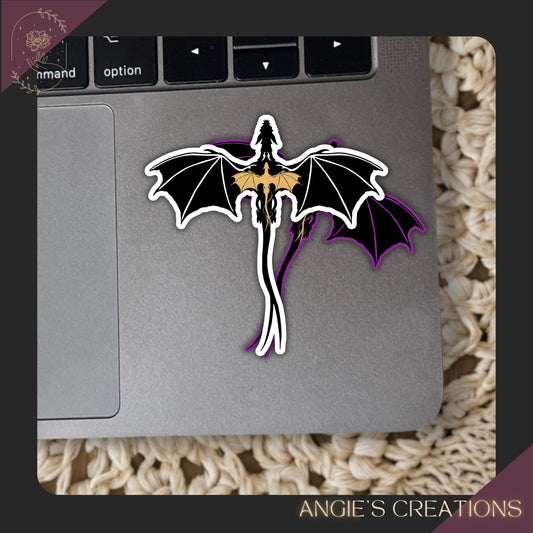 A sticker of a dragon is placed on a laptop keyboard.