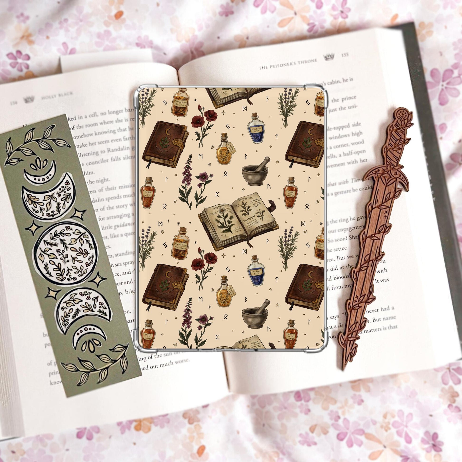 Handmade cream Kindle insert with hand drawn apothecary books, herb bundles, potion bottles and mortar and pestle illustrations in a repeating pattern, displayed on an open book