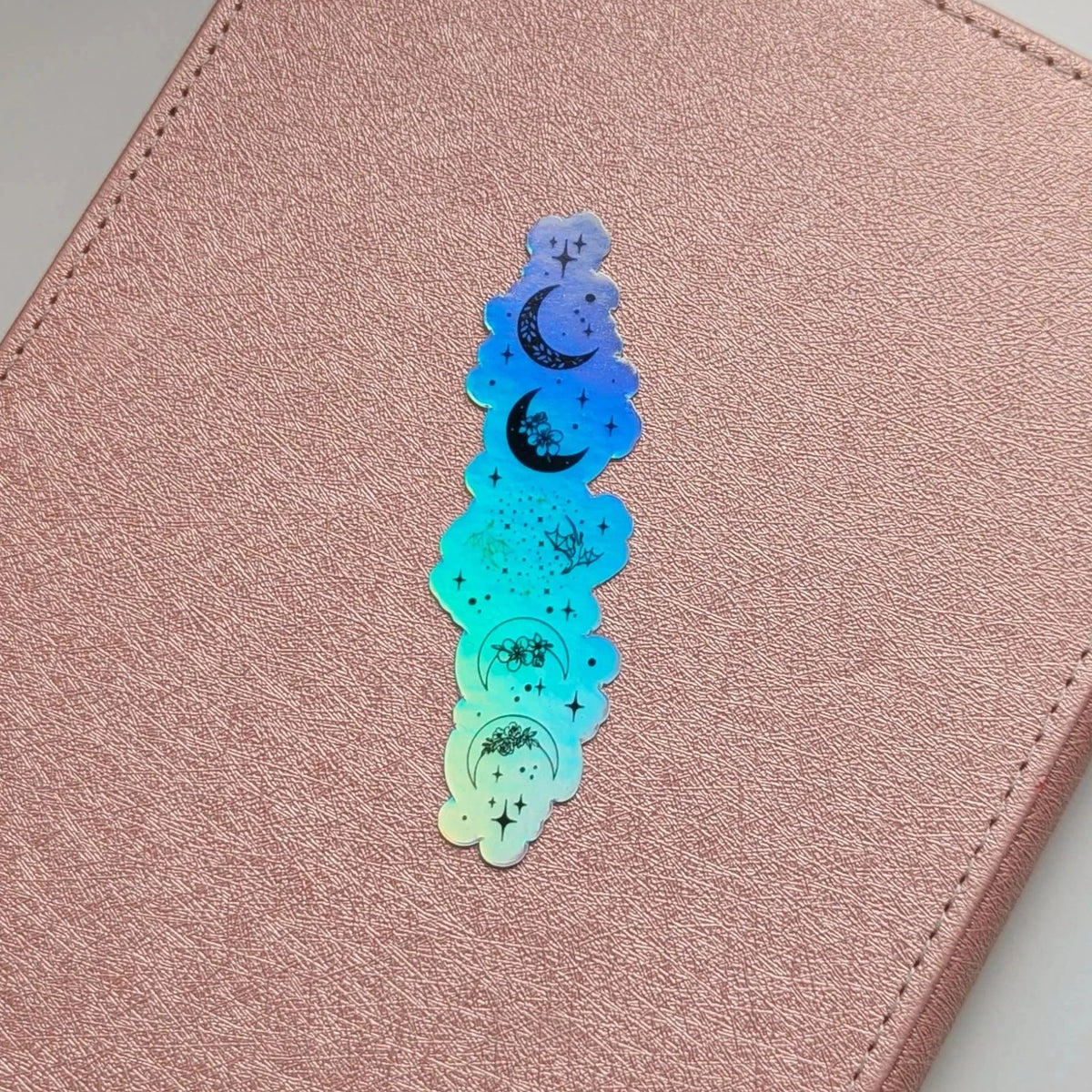 Holographic star and moon design on a pink leather surface