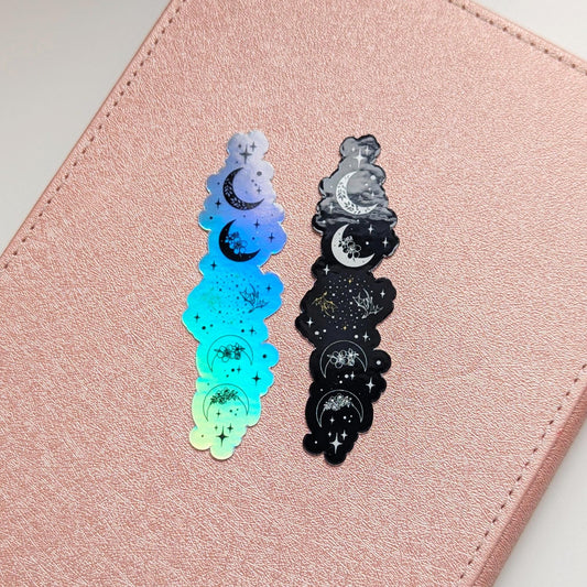 Vertical moon phase sticker strip in two colorways, one holographic blue-green and one black, featuring crescent moons, stars, and floral accents from top to bottom, inspired by Fourth Wing and Iron Flame.