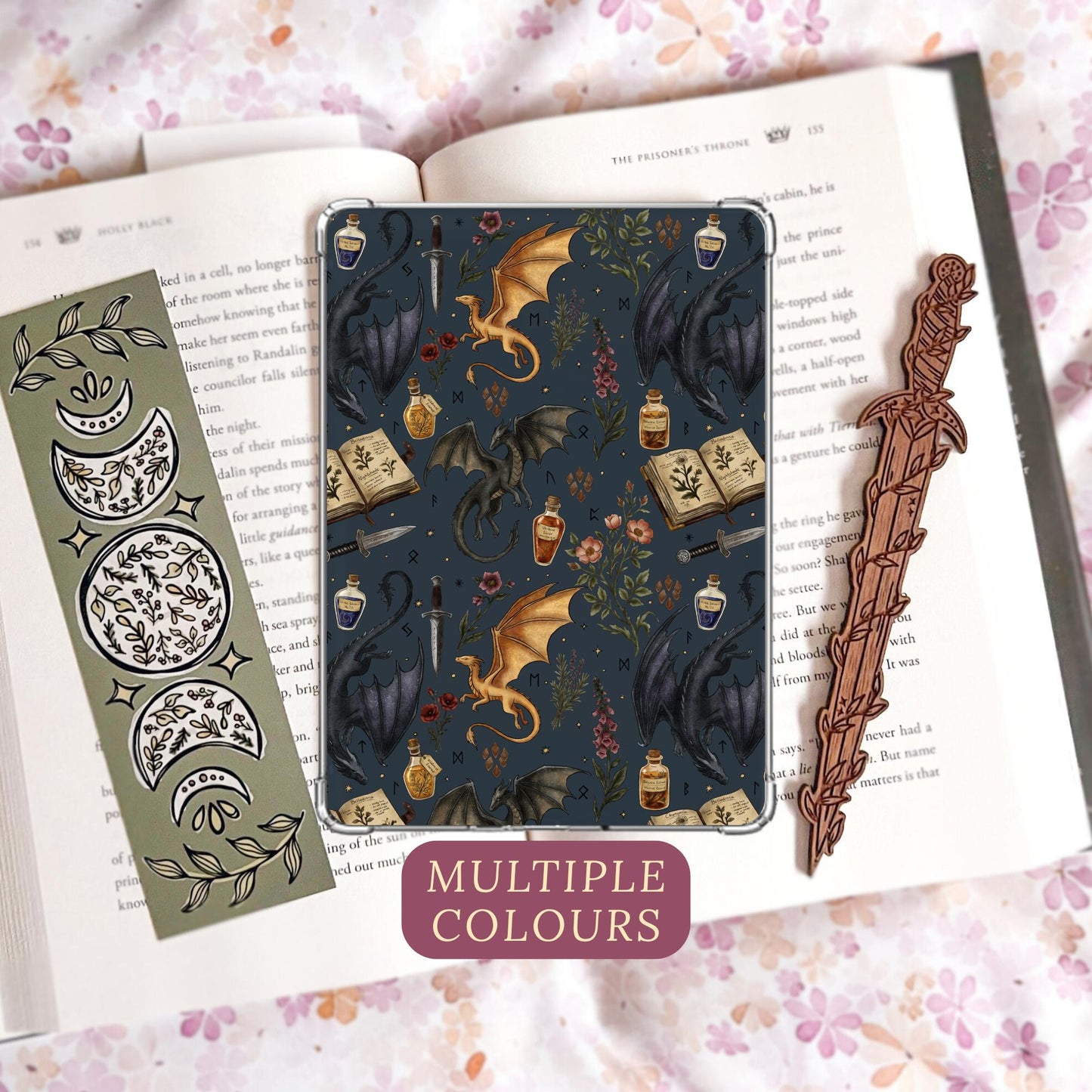 Handmade navy blue Kindle insert featuring hand drawn black and gold dragons, potion bottles, an open spell book and wildflowers in a repeating pattern, displayed on an kindle